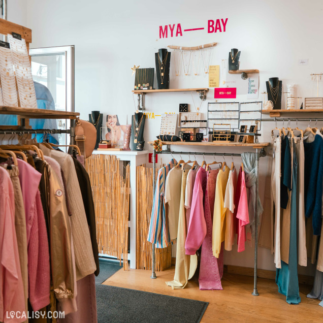 Rayons de vêtements et d'accessoires, avec un présentoir de bijoux Mya-Bay, dans le magasin Native Boutique à Huy.