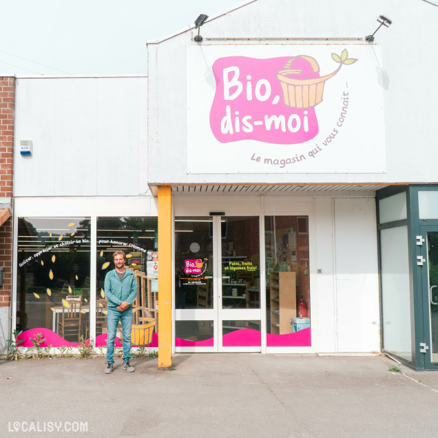 Façade du magasin bio Bio, dis-moi à Tihange, avec un homme posant devant l'entrée.