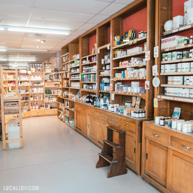 Vue des étagères en bois remplies de compléments alimentaires et de produits de bien-être dans le magasin Bio, dis-moi à Tihange.