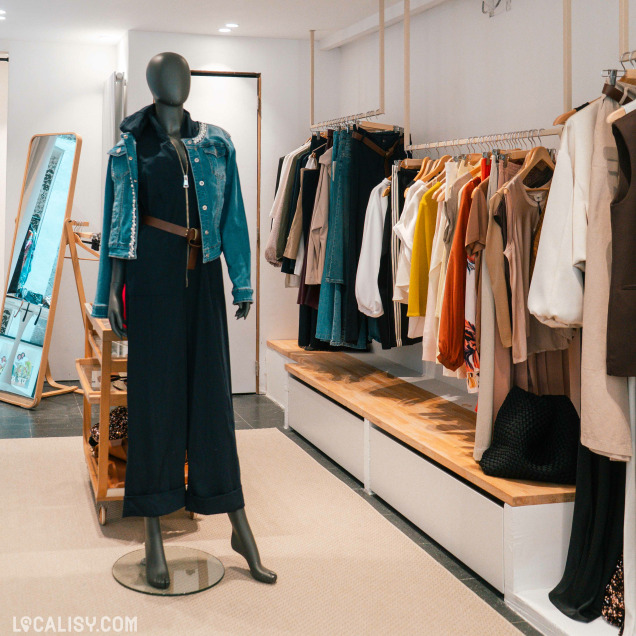 Mannequin en tenue tendance et portants de vêtements dans le magasin Up now à Huy.