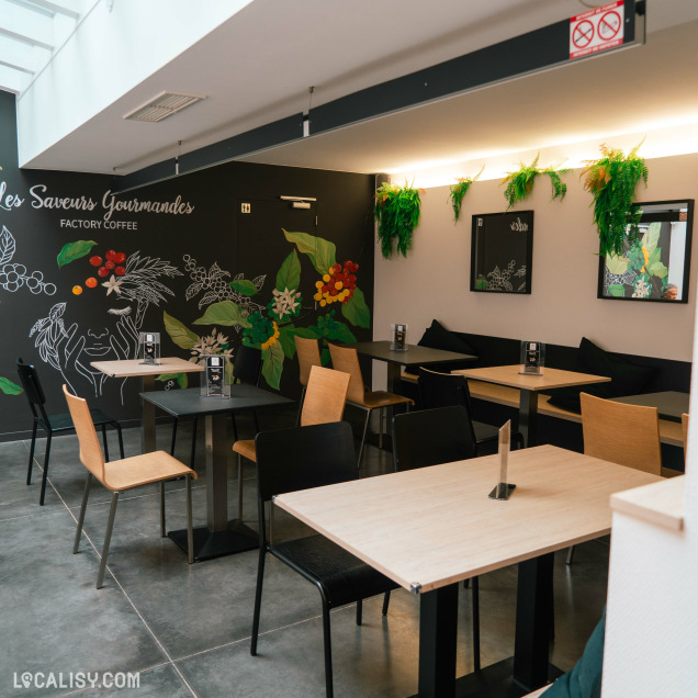Espace dégustation cosy, décoré d’une fresque murale colorée et de touches végétales.