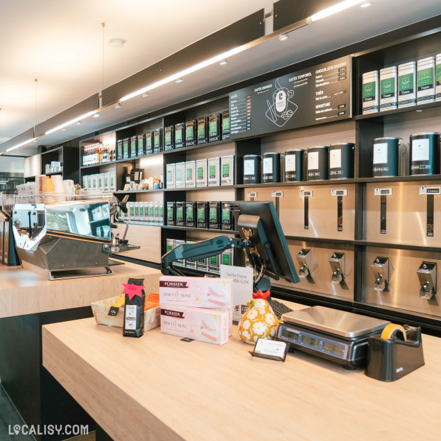 Comptoir de service mettant en valeur thés, cafés et douceurs artisanales dans une ambiance chaleureuse.